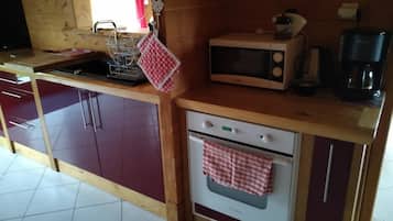 A compact kitchen with a microwave, coffee maker, and a small oven.