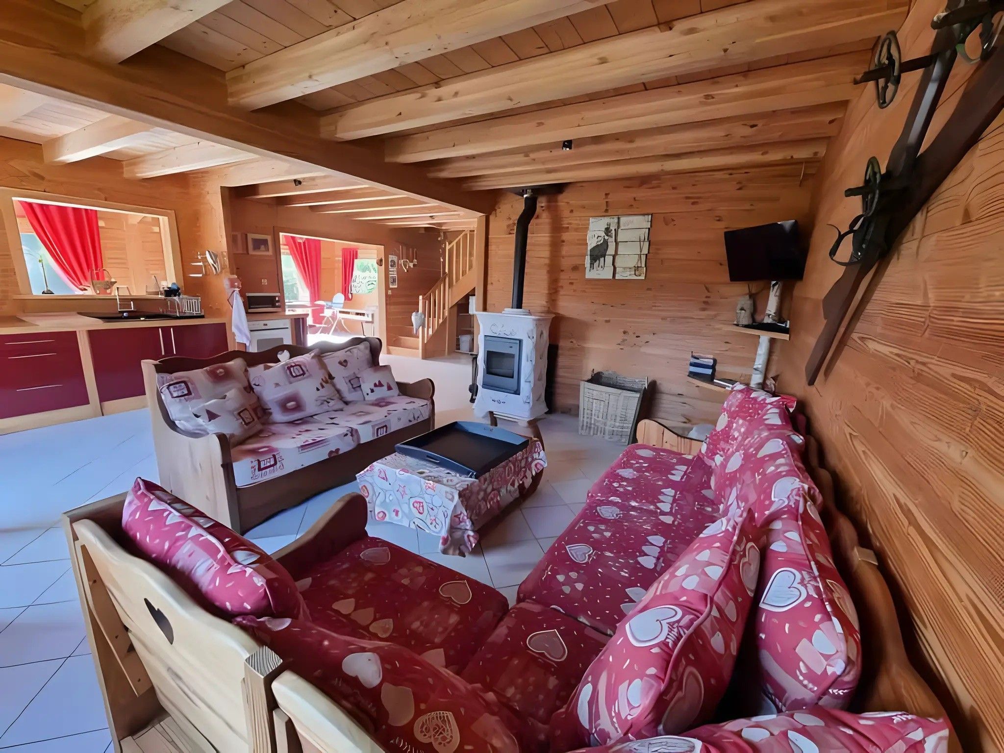 Een gezellig houten interieur met een bank, een televisie en een open haard.