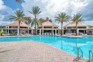 A hotel with a swimming pool, palm trees, and a clear sky. - 4404 Harbour Village (Ponce Inlet)