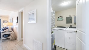 A laundry room with a washer and dryer, a vent, and a sign indicating laundry service. - 602 Sand Castle So in Ponce Inlet, FL (Ponce Inlet)