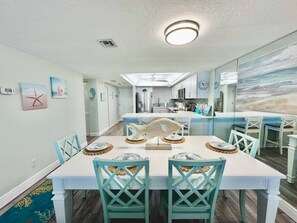 A dining area with a white table, teal chairs, and a fish centerpiece. - #604 Blue Surf 2/2 Oceanfront Condo On Traffic Free Beach (Daytona Beach Shores)