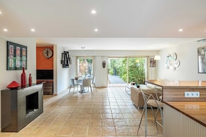 A spacious kitchen with a dining area, a fireplace, and a view of the outdoors. - Family Apartment with Pool & Garden 5 P - Cannes (Cannes)