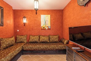 A room with a sofa set, a television, and a wall-mounted light fixture. - Family Apartment with Pool & Garden 5 P - Cannes (Cannes)