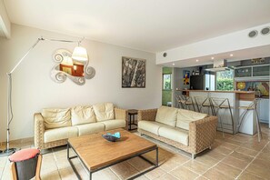Un salon avec un canapé, une table basse et un lampadaire.