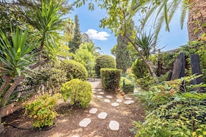 A garden with a stone pathway, various shrubs, and a neatly trimmed hedge. - Family Apartment with Pool & Garden 5 P - Cannes (Cannes)