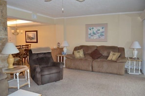 A living room with a leather armchair, a sofa, and two side tables with lamps. - #604 Sandcastle 2/2 Oceanfront condo - Traffic Free Beach (Ponce Inlet)