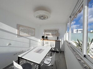 A sunlit room with a table and chairs, a decorative cabinet, and framed artwork on the walls. - Casa Sirius-Private Pool by Lanzarote Vacation Homes (Playa Blanca)