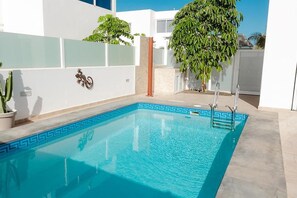 A swimming pool with a geometric tile pattern, a cactus plant, and a wall-mounted lizard decoration. - Casa Sirius-Private Pool by Lanzarote Vacation Homes (Playa Blanca)