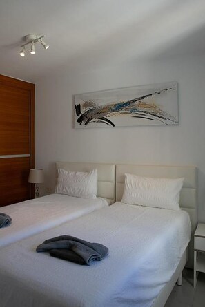 A hotel room with a double bed, a bedside table, a lamp, and a ceiling light fixture. - Casa Sirius-Private Pool by Lanzarote Vacation Homes (Playa Blanca)