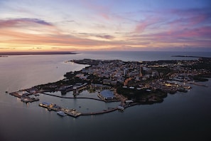 An aerial view of a coastal city with a marina, buildings, and a large body of water. - 2-Bed 2-Bath Apartment Near Darwin Attractions (Darwin City)