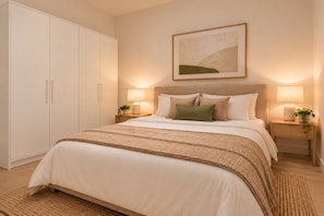 Ein Schlafzimmer mit Bett, Nachttischen, einem Kleiderschrank und einem gerahmten Bild an der Wand.