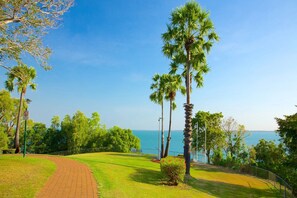 A golf course with a clear view of the ocean, surrounded by palm trees and a brick pathway. - Contemporary 2-Bed Apartment In Darwin CBD (Darwin City)