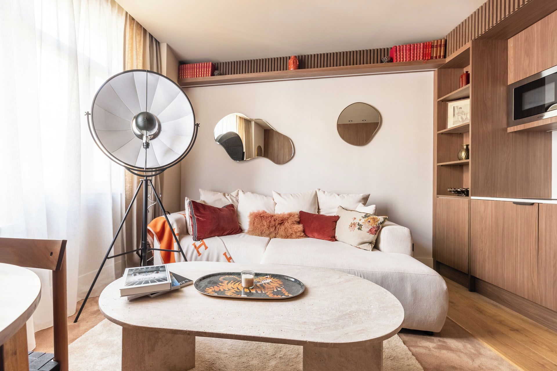 A modern bedroom with a sofa, a coffee table, a floor lamp, and a TV.