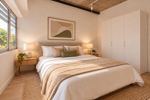 A bedroom with a bed, bedside tables, a nightstand, a lamp, a framed picture, and a wardrobe. - Family Friendly 2-Bed Apartment Darwin City (Darwin City)