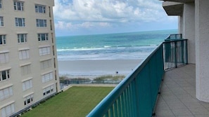 Ein Balkon mit Blick auf den Ozean und einem Gebäude im Hintergrund.