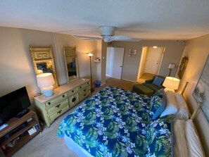 A bedroom with a bed, dresser, television, and a ceiling fan. - #705 Sandcastle 2/2 Oceanfront CondoTraffic Free Beach (Ponce Inlet)