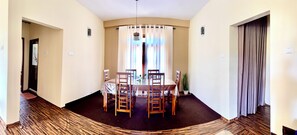 Un coin repas avec une table ronde, des chaises et une plante en pot.