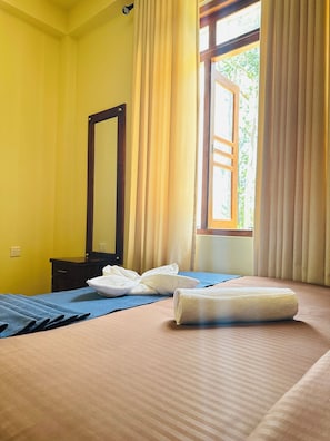 A hotel room with a bed, a mirror, and a window with curtains. - ELLA FOOD & BED (Ella)