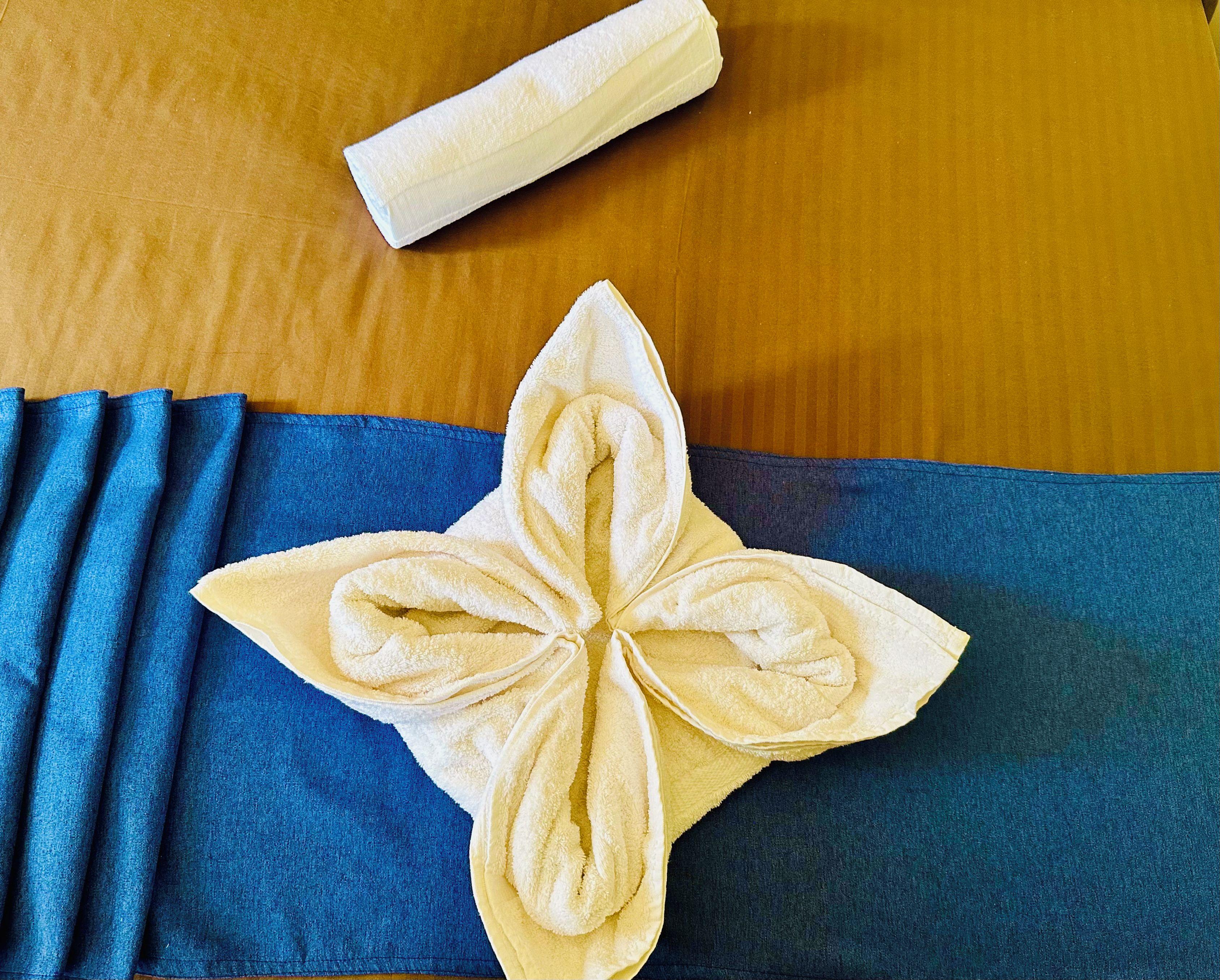 A folded towel with a floral pattern on a wooden surface.