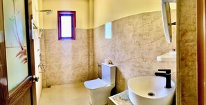 Une salle de bain avec des toilettes, un lavabo et une douche.