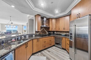 Una cocina moderna con armarios de madera, electrodomésticos de acero inoxidable y una isla grande con pileta.