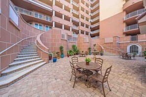 A multi-level outdoor patio with a spiral staircase, outdoor seating, and potted plants. - 707 Bella Vista in Daytona Beach Shores, FL (Daytona Beach Shores)