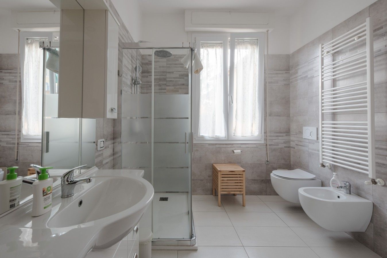 Ein modernes Badezimmer mit Duschkabine aus Glas, freistehender Badewanne und einem Doppelwaschtisch.