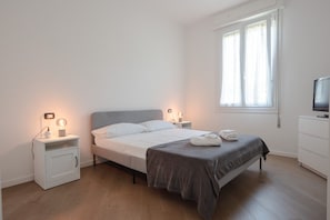 A bedroom with a bed, bedside tables, a TV, and a window. - Gulli 19 City Flat - 2 bdrs apartment (Parma)
