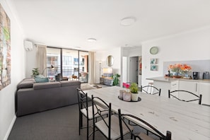 A modern apartment with a dining area, kitchen, and a balcony with a view. - Spacious 2-Bed Apartment Near Parramatta CBD (Parramatta)