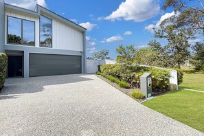 Ein modernes, zweistöckiges Haus mit Garage, Kiesweg und gepflegtem Rasen.