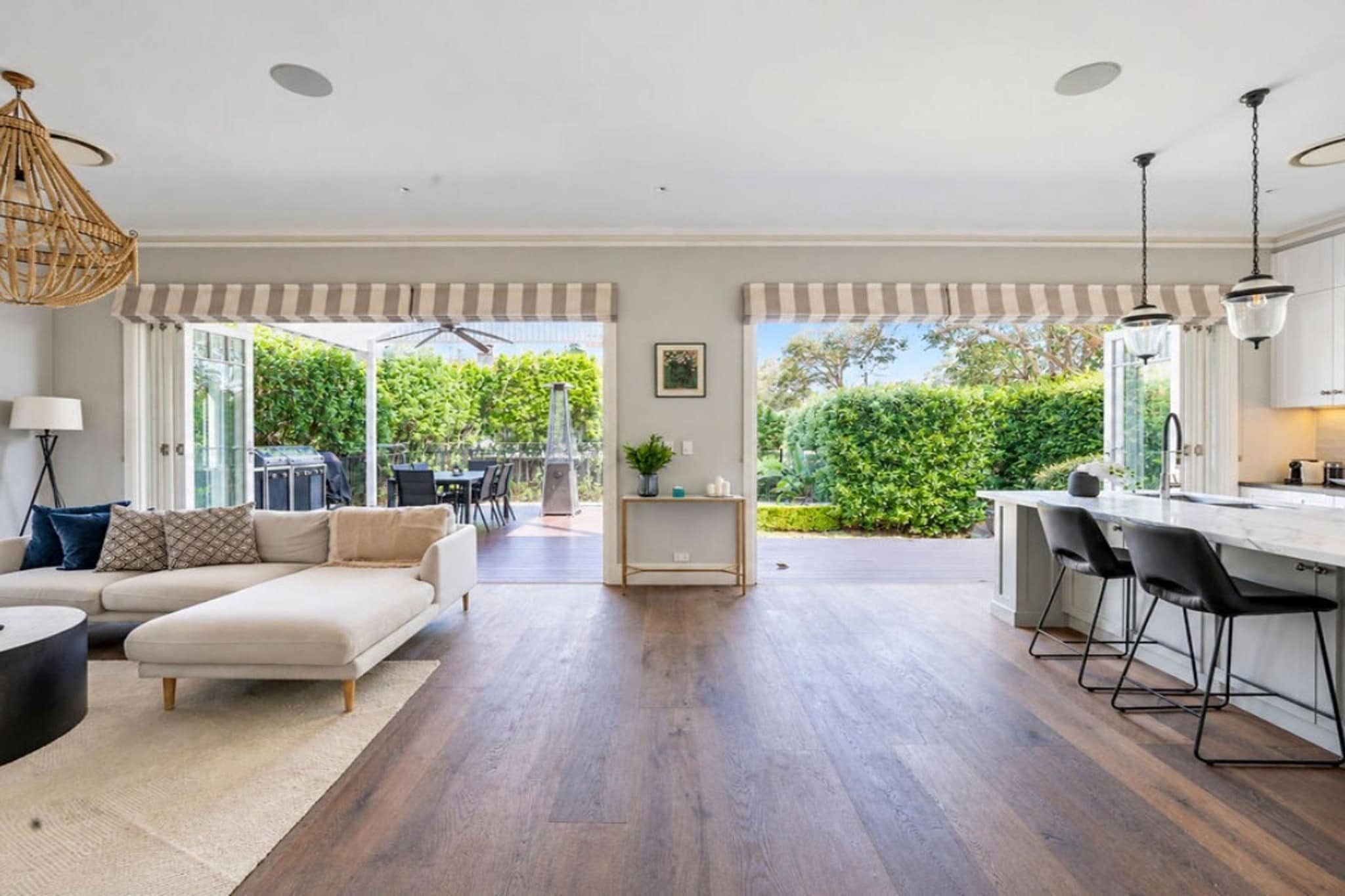 A spacious living area with a sofa, a dining table, and a kitchen area with bar stools.