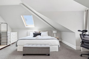 A bedroom with a bed, a desk, a chair, a window, and a skylight. - Spacious 4-Bed House with Pool in Mosman (Mosman)