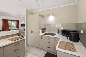 A modern kitchen with a countertop, cabinets, a sink, and a coffee machine.
