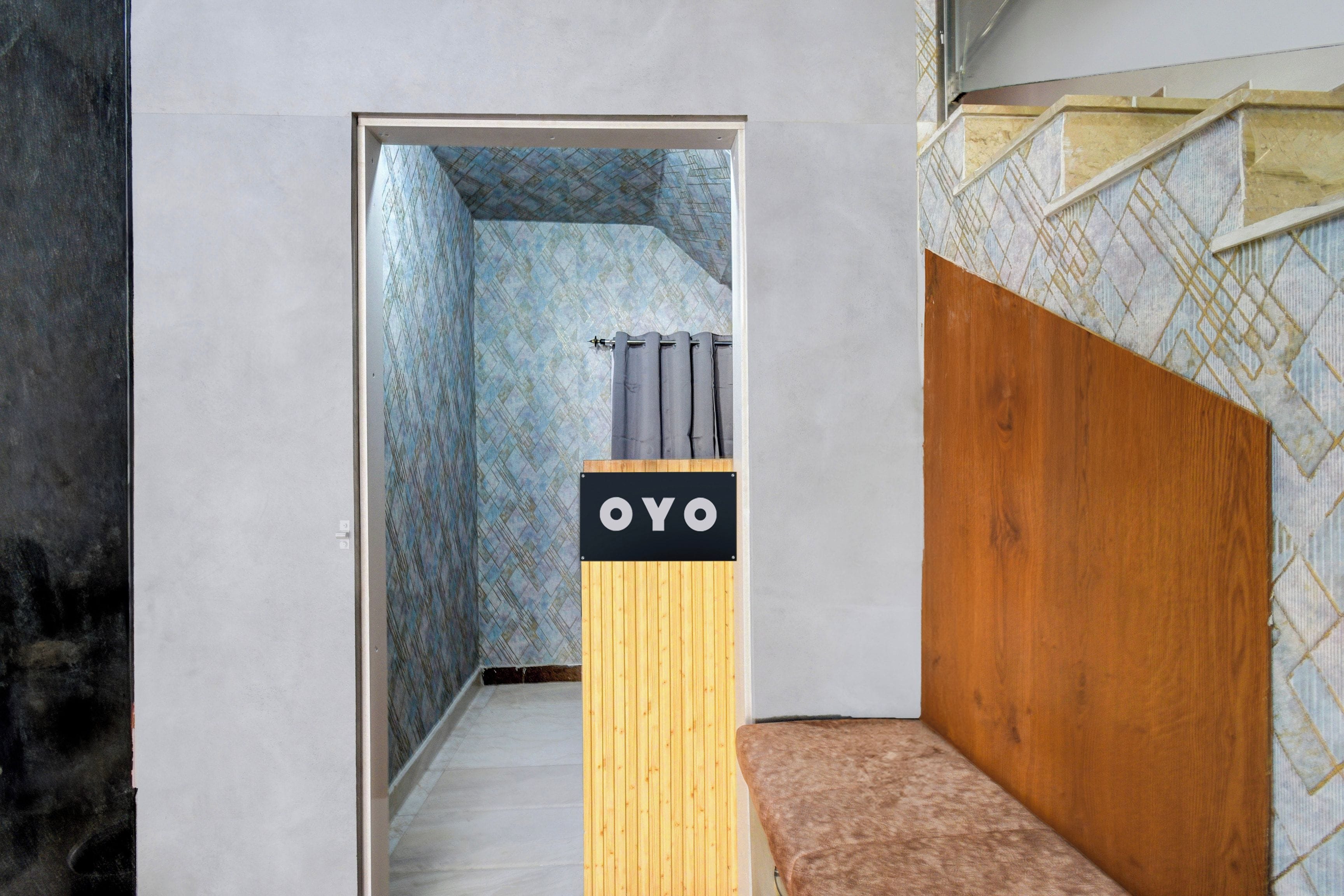 Un pasillo estrecho con un banco de madera a la derecha y una puerta al final.