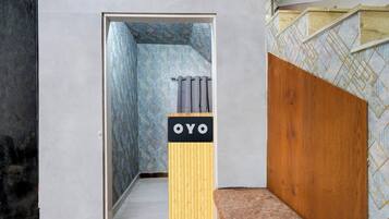 Un pasillo estrecho con un banco de madera a la derecha y una puerta al final.