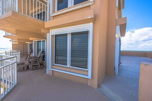 En balkon med skydedør, udendørs møbler og havudsigt.