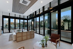 A modern interior with a seating area, large windows, and a view of the outdoors. - Luxury Chevron Island Retreat | Water & City Views (Surfers Paradise)