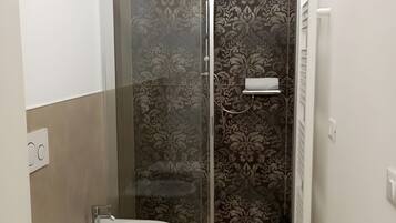 Une salle de bain équipée d’une douche, de toilettes et d’un bidet.