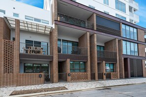 A modern multi-story building with a brick facade, large windows, and balconies. - Spacious 3-Bed Townhouse In Mile End (Mile End)