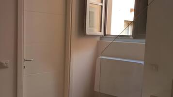 Ein Zimmer mit einer Tür, einem Fenster und einer Treppe.