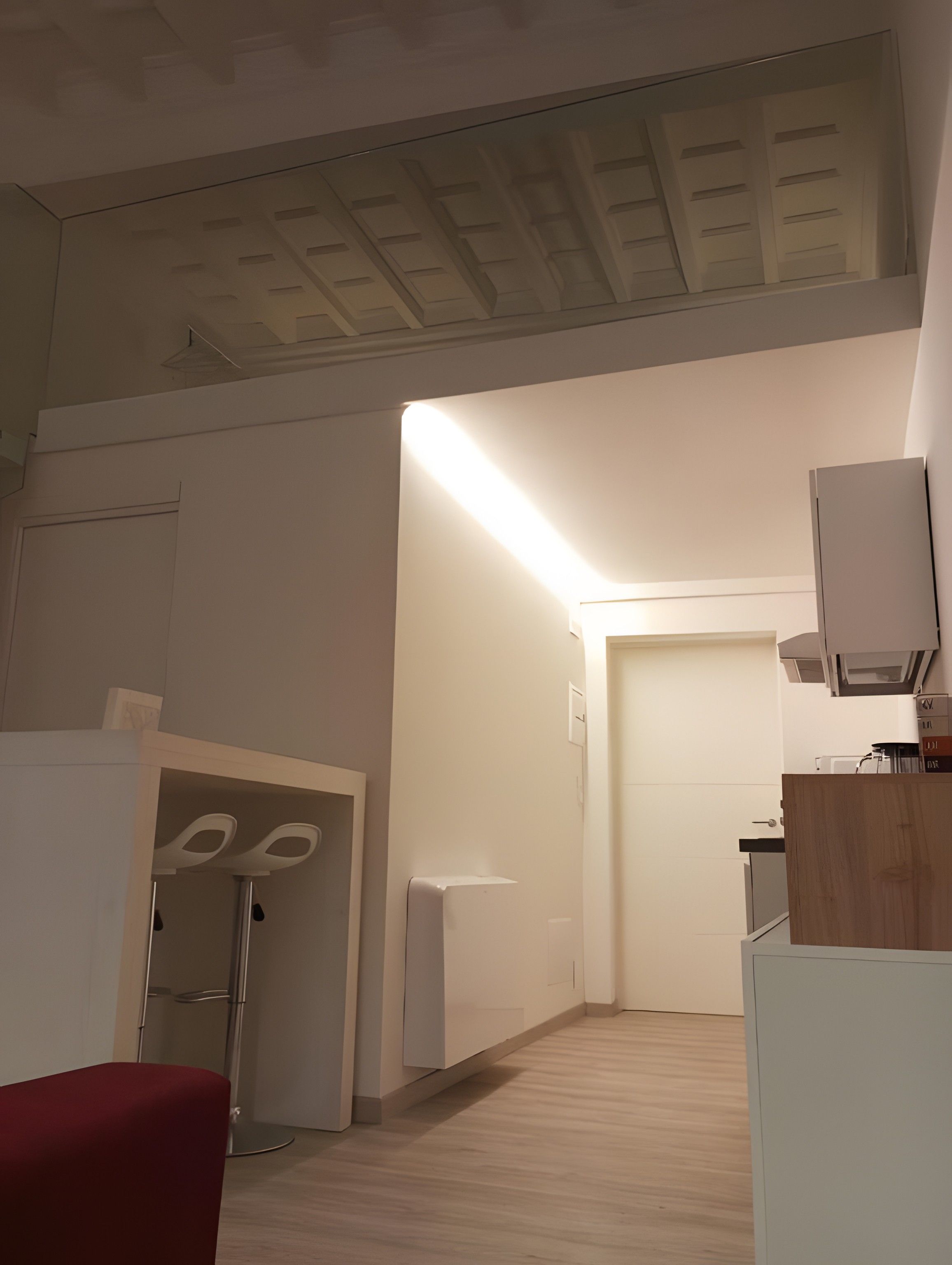 Une cuisine moderne avec des meubles blancs, un four encastré et un four à micro-ondes.