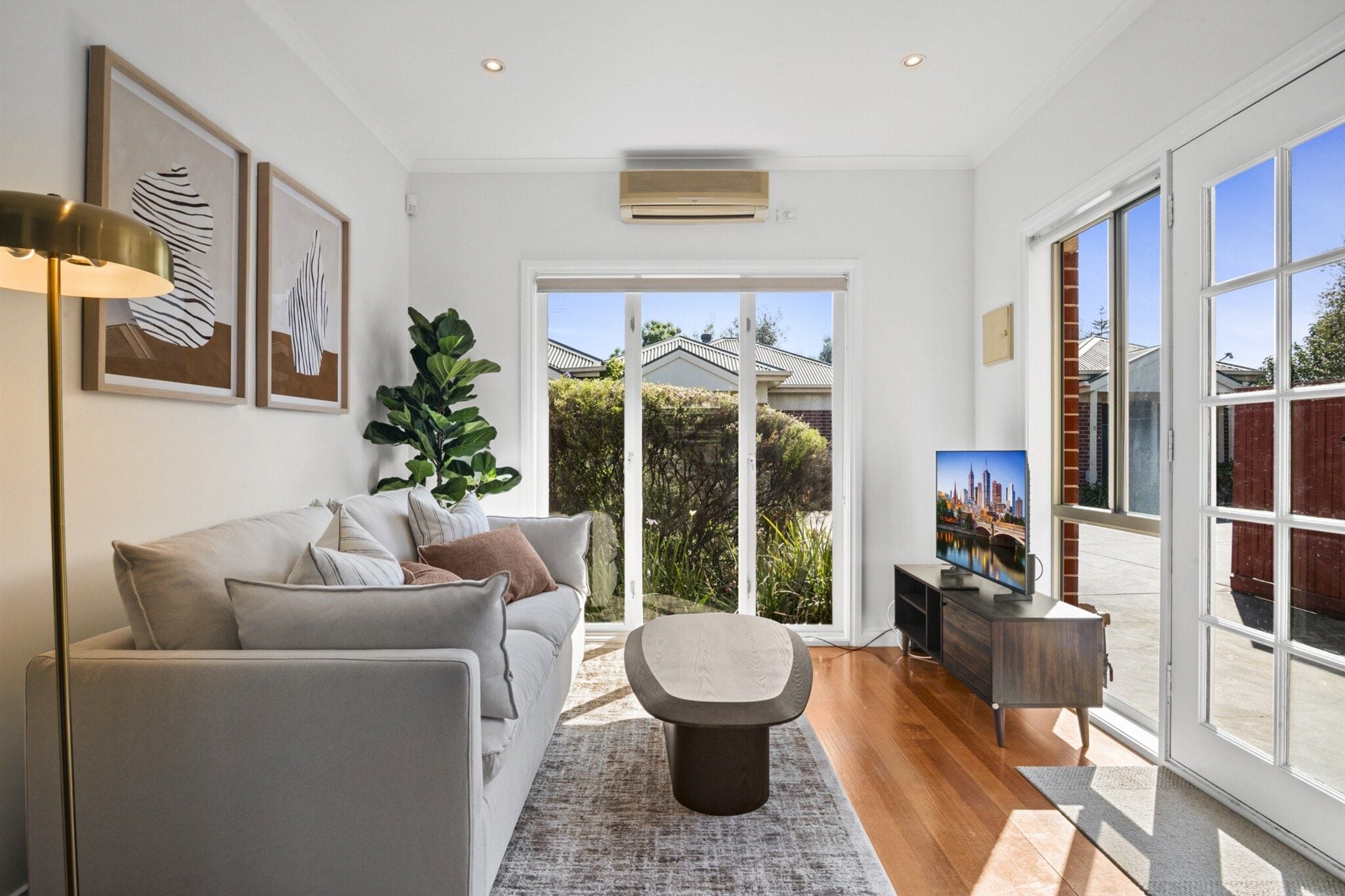 A modern living room with a sofa, coffee table, and artwork on the walls.