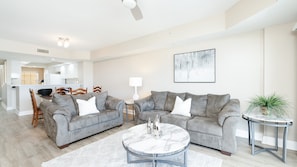 A modern living room with two grey sofas, a marble coffee table, and a small side table with a plant. - A506 Links South in Ponce Inlet, FL (Ponce Inlet)