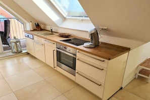 Eine moderne Küche mit Oberlicht, Backofen und Kaffeemaschine.