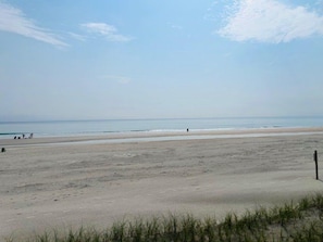 A beach with a clear sky, sandy shore, and a few people in the distance. - #606 Atlantica Oceanfront 2/2 Condo. (Ponce Inlet)