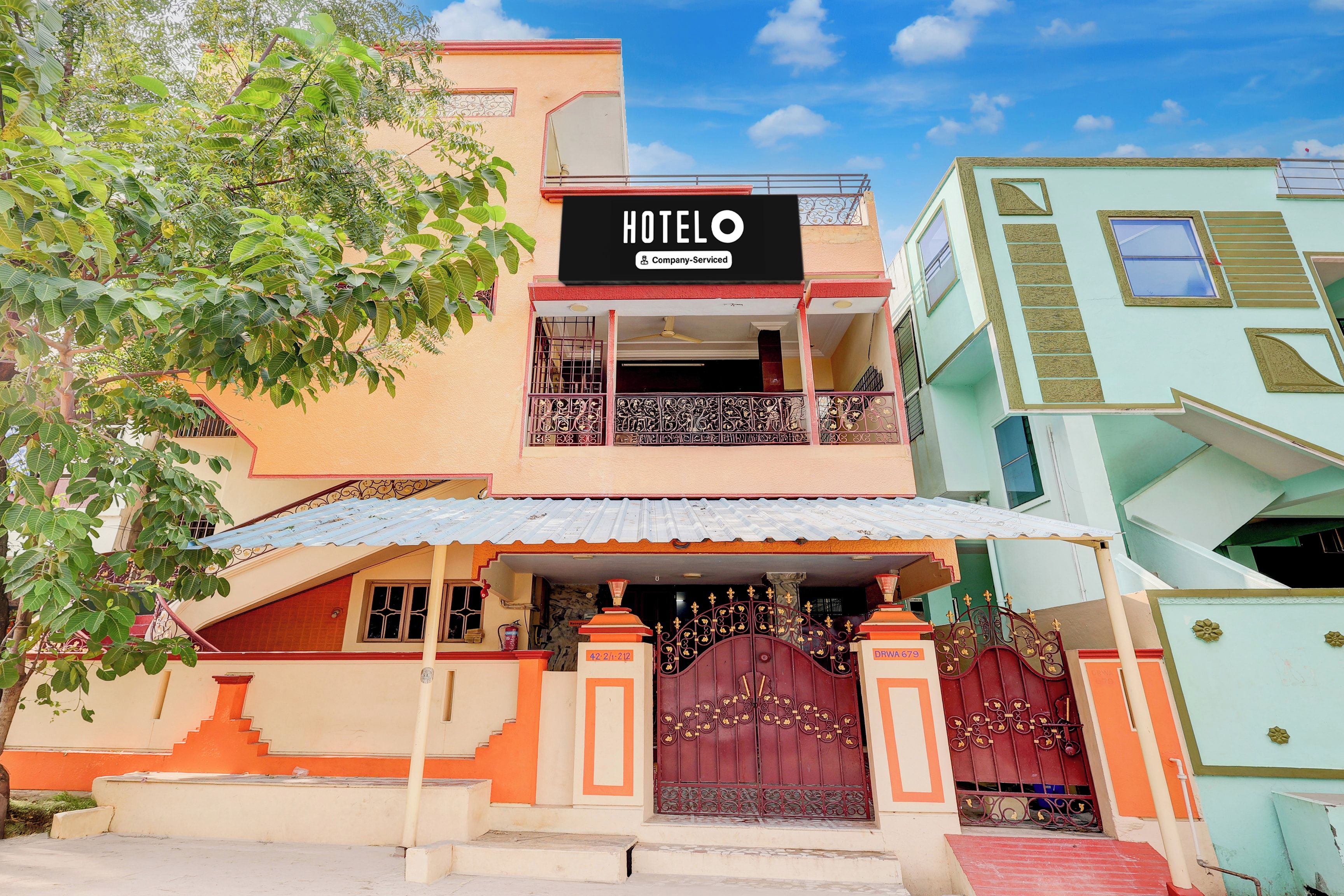 A two-story hotel with a sign reading 'HOTELO & Company-Serviced' above the entrance.