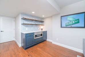 A kitchen with blue cabinets, a built-in oven, and a backsplash with a geometric pattern. - Coastal Luxury at the Blue Surf 301 (Daytona Beach Shores)