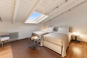 A bedroom with two beds, a radiator, a chair, a tray with drinks, and a skylight. - Daydream in Villa Pozzi (Villa Pozzi)