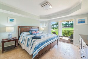 Un dormitorio con cama, mesitas de noche y vistas al exterior a través de un ventanal.