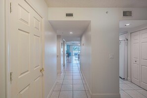 A hallway with white doors, a tiled floor, and recessed lighting. - D-407 Links North in Ponce Inlet, FL (Ponce Inlet)
